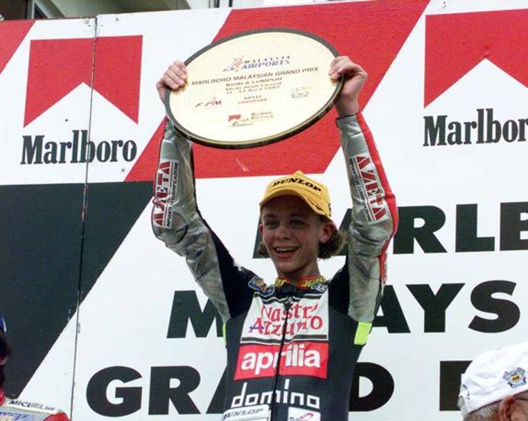 Primo titolo iridato di Valentino Rossi: a soli 18 anni il pesarese si impone in 125 in sella all’Aprilia. Milagro